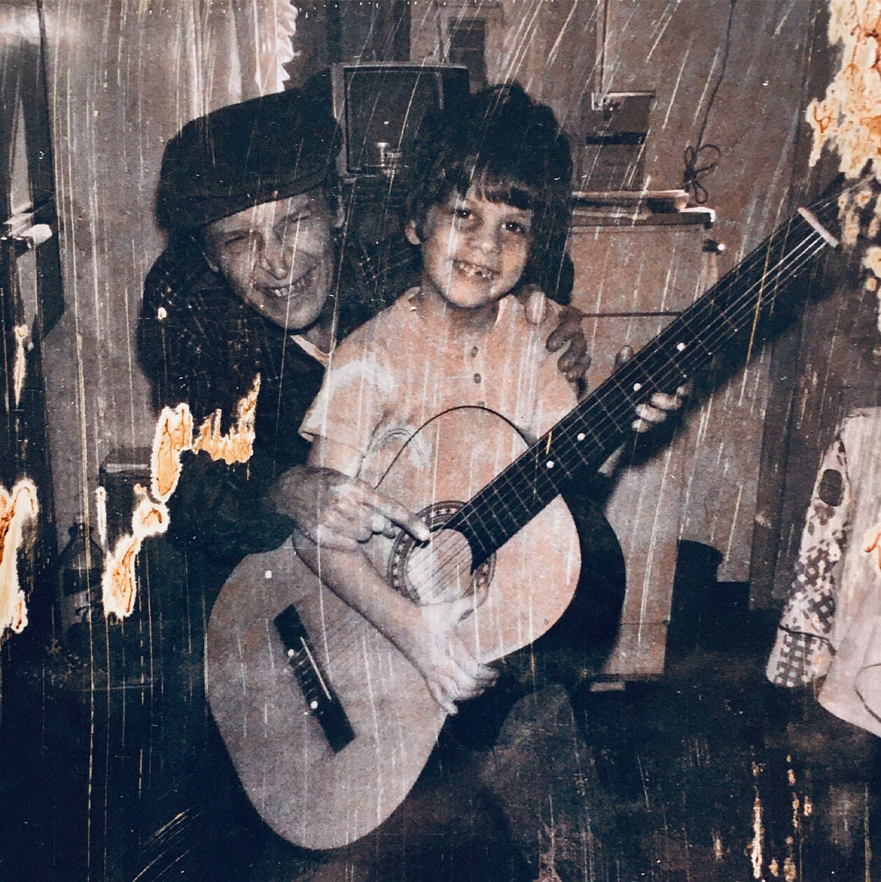 An old photograph of Ed Marra holding a guitar with his uncle